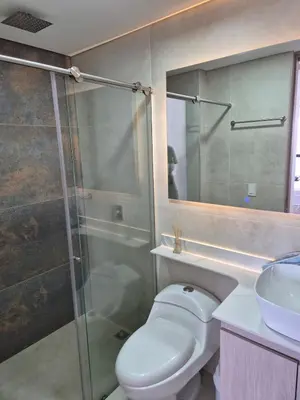 a bathroom with a toilet and a sink and a shower at Laureles 11th Floor, Jacuzzi and AC in Medellín