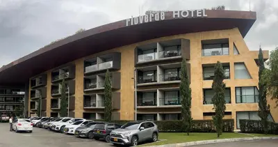 a hotel with cars parked in front of it at Suite Rioverde Hotel Rionegro in Rionegro