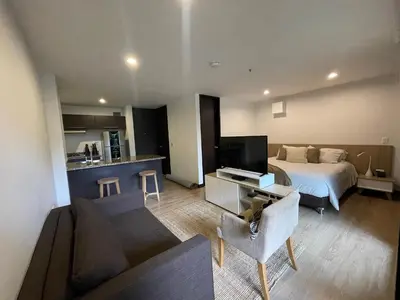 a hotel room with a bed and a living room at Suite Rioverde Hotel Rionegro in Rionegro