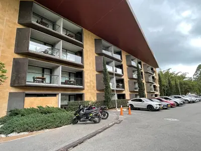 a parking lot with a motorcycle parked in front of a building at Suite Rioverde Hotel Rionegro in Rionegro