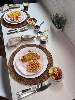 a table with three plates of food and waffles and fruit at Ohana in Medellín