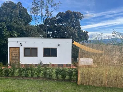 a white house behind a fence with a fence at Ohana in Medellín