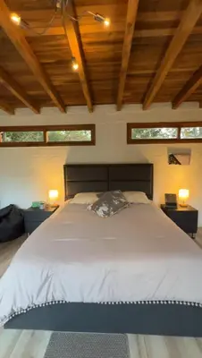 a large bed in a room with two windows at Ohana in Medellín