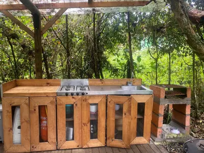 an outdoor kitchen with a sink in a wooden deck at Cabernet Cabaña - La Cava Lodge in Medellín