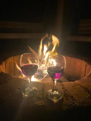 two glasses of wine sitting in front of a fire at Cabernet Cabaña - La Cava Lodge in Medellín
