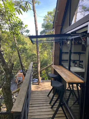 a porch of a house with a table and a bench at Cabaña Lambrusco - La Cava Lodge in Medellín