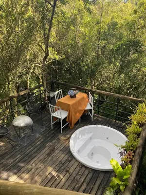 a wooden deck with a table and a bath tub at Cabaña Lambrusco - La Cava Lodge in Medellín