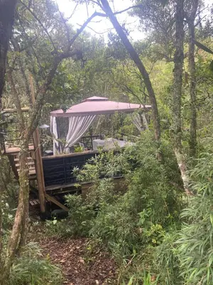 a gazebo with a canopy in the woods at Cabaña Lambrusco - La Cava Lodge in Medellín