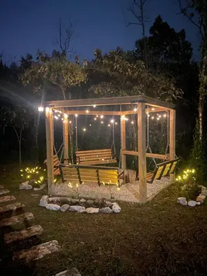 a wooden bench with lights in a park at night at Cabaña Lambrusco - La Cava Lodge in Medellín