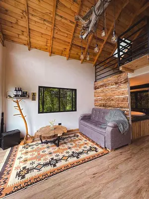 a living room with a couch and a table at Cabaña Malbec - La Cava Lodge in Medellín