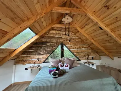 a bedroom with a bed in a attic at Cabaña Malbec - La Cava Lodge in Medellín