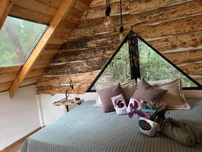 a bedroom in a tree house with a bed at Cabaña Malbec - La Cava Lodge in Medellín