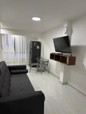 a living room with a couch and a flat screen tv at Apartamento cálido in Medellín