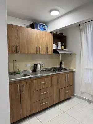 a kitchen with wooden cabinets and a sink at Apartamento cálido in Medellín