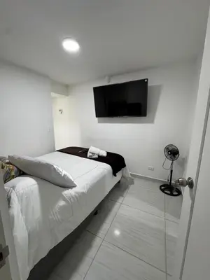 a bedroom with a bed and a flat screen tv at Apartamento cálido in Medellín