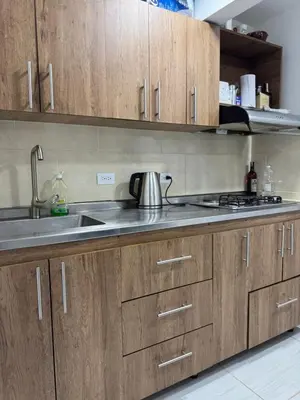 a kitchen with wooden cabinets and a sink at Apartamento cálido in Medellín