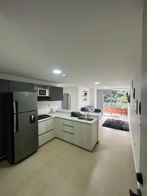 a kitchen with white cabinets and a black refrigerator at Comfortable apartment in Sabaneta in Sabaneta