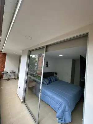 a bed in a room with a glass wall at Comfortable apartment in Sabaneta in Sabaneta