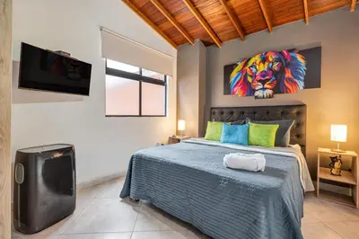 a bedroom with a bed with a painting of a lion at Dazzling Apartment con Aire acondicionado in Envigado