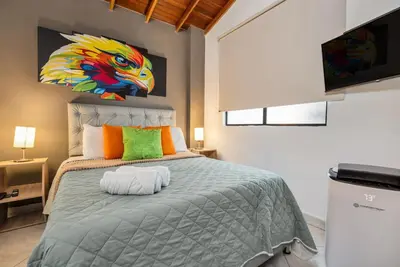a bedroom with a bed with a painting on the wall at Dazzling Apartment con Aire acondicionado in Envigado