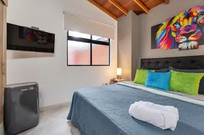 a bedroom with a blue bed and a tv at Dazzling Apartment con Aire acondicionado in Envigado