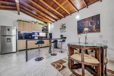 a kitchen with a table and stools in a room at Dazzling Apartment con Aire acondicionado in Envigado