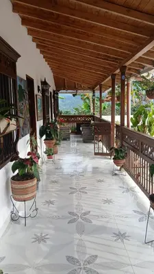 a porch with potted plants on a tile floor at finca nalu in Jardin
