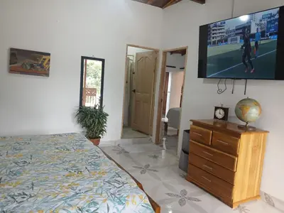 a bedroom with a bed and a flat screen tv at finca nalu in Jardin