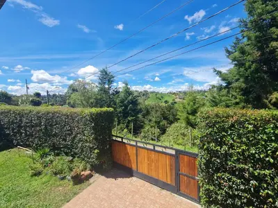 a house with a wooden fence and hedge at Aparta estudio campestre in Rionegro