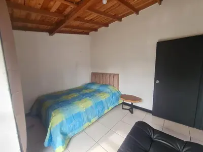 a small bedroom with a bed and a table at Aparta estudio campestre in Rionegro