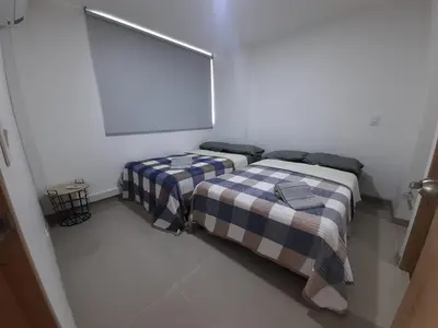 a bedroom with two beds in a white room at Luxury apartment citadela di sole , santafe de antioquia in Santa Fe de Antioquia