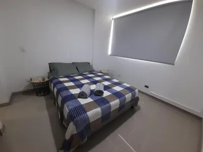 a bedroom with a bed in a white room at Luxury apartment citadela di sole , santafe de antioquia in Santa Fe de Antioquia