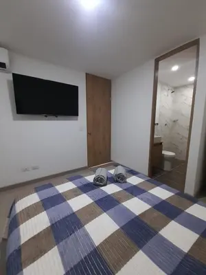 a bedroom with a bed with a tv on the wall at Luxury apartment citadela di sole , santafe de antioquia in Santa Fe de Antioquia