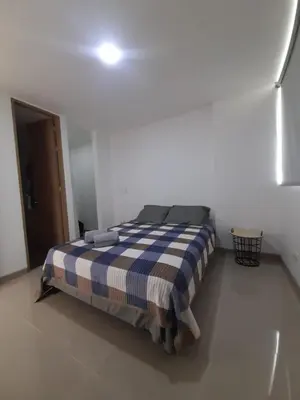a bedroom with a bed with a blue and white blanket at Luxury apartment citadela di sole , santafe de antioquia in Santa Fe de Antioquia
