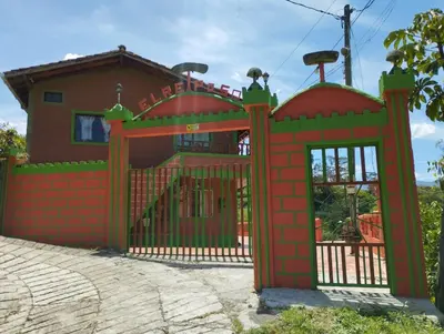 a red gate in front of a house at ENTRE LOMAS GLAMPING - Finca el Reposo in Girardota