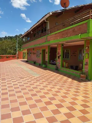 a building with a checkered floor in front of it at ENTRE LOMAS GLAMPING - Finca el Reposo in Girardota