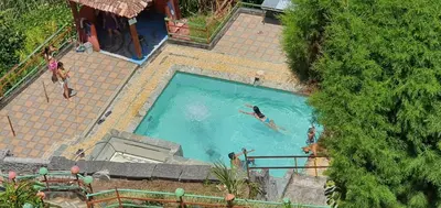 an overhead view of two people swimming in a swimming pool at ENTRE LOMAS GLAMPING - Finca el Reposo in Girardota