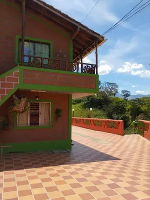 a house with a balcony on the side of it at ENTRE LOMAS GLAMPING - Finca el Reposo in Girardota