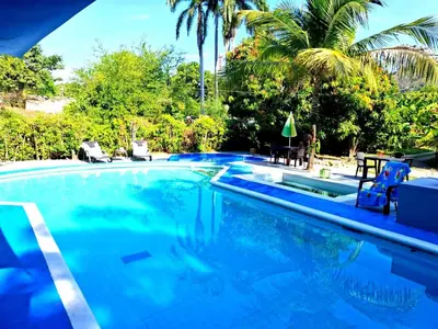 a swimming pool with blue water and palm trees at cabaña in Honda