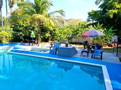 a pool with chairs and a table and an umbrella at cabaña in Honda