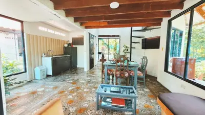 a living room with a table and a kitchen at cabaña in Honda