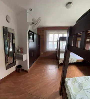a room with two bunk beds and a wooden floor at Hermosa Casa Familiar in Santa Fe de Antioquia