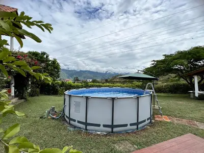 a hot tub in a yard with an umbrella at Hermosa Casa Familiar in Santa Fe de Antioquia