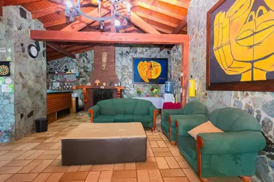 a living room with green chairs and a table at Finca Hotel Santo Tomas Campestre in Rionegro
