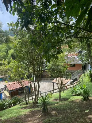 a group of trees with a building in the background at Finca Hotel Santo Tomas Campestre in Rionegro