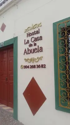 a sign on the side of a building with a door at La casa de la abuela in Jericó