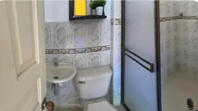 a bathroom with a toilet and a sink and a shower at La casa de la abuela in Jericó