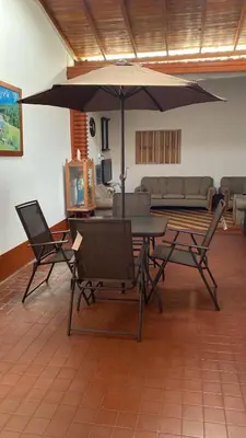 a living room with a table and chairs and an umbrella at La casa de la abuela in Jericó