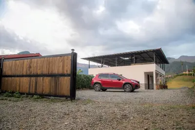 a red car parked in front of a house at habitación campestre para pareja JAZMIN in Jardin
