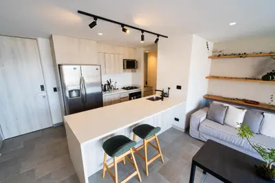 a kitchen and living room with a counter and a couch at The best location in Poblado Air conditioning in Medellín